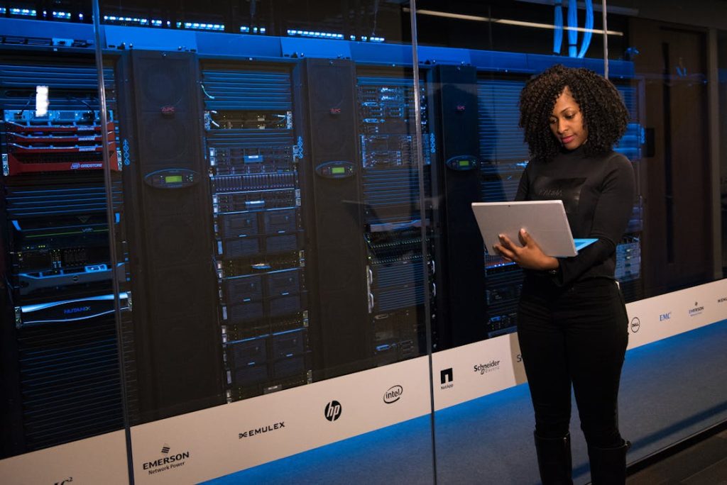 Data center technician in front of server cabinets